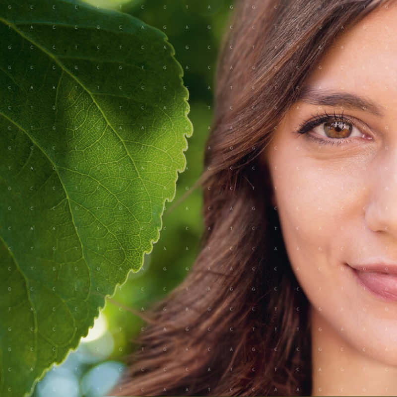 Metà foglia verde e metà viso di una ragazza sono affiancate e circondate da piccole lettere che rappresentano la sequenza di DNA